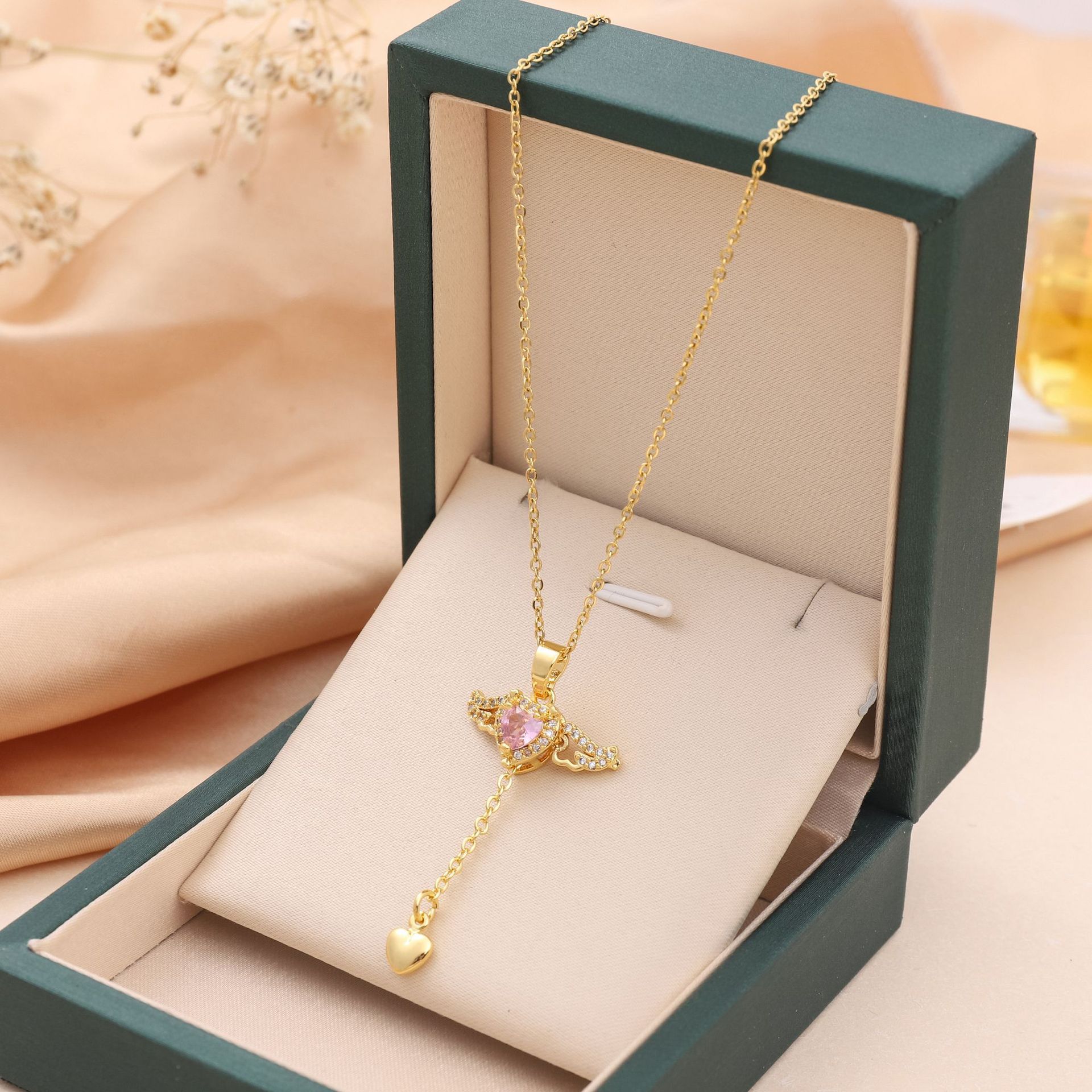 Amorital angel wings necklace with pink heart crystal — gold and silver pendant symbolizing love, luck, purity, and protection